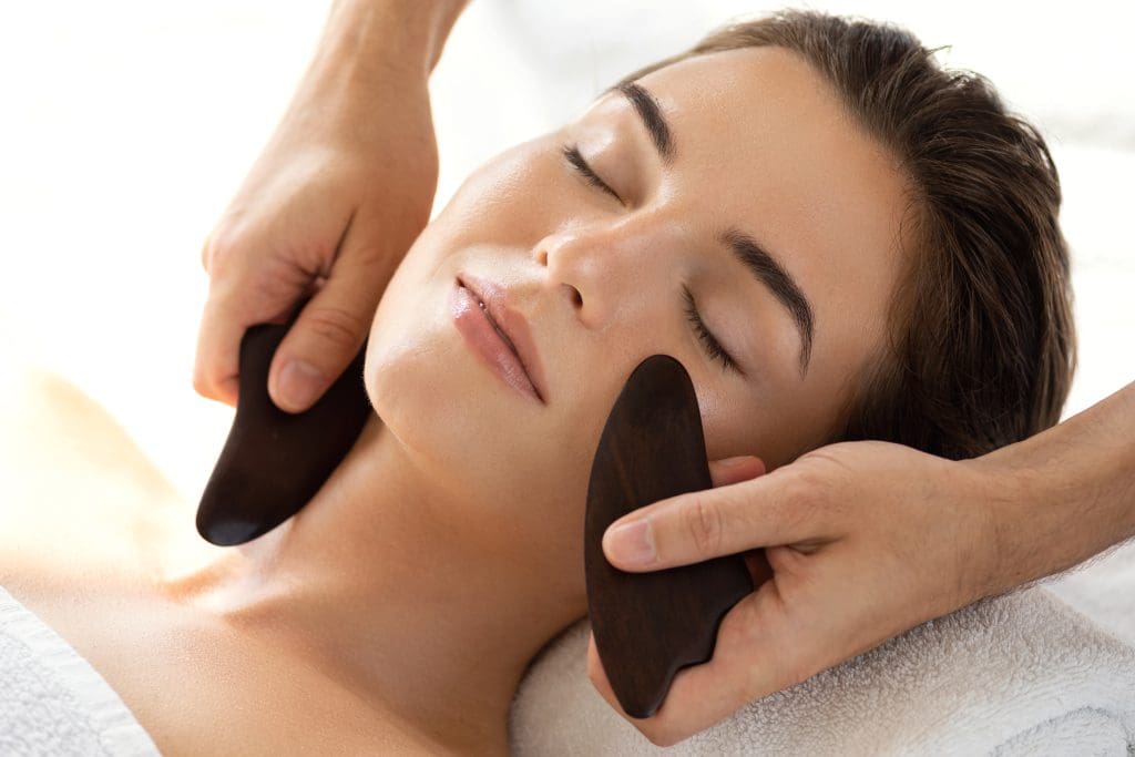 a woman get a gua sha facial