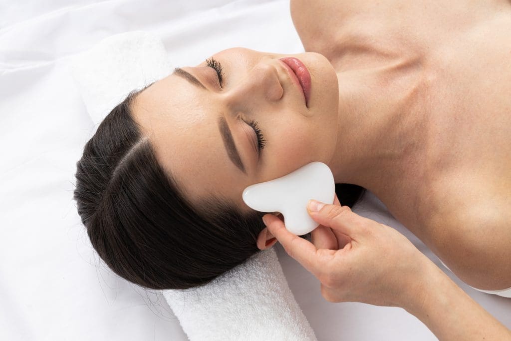 a woman getting a gua sha facial improve circulation