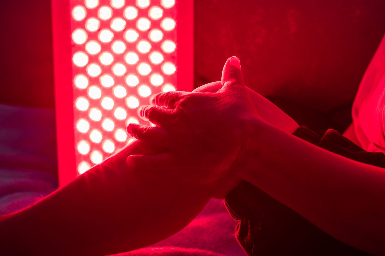 a man treating his sore leg with red light therapy