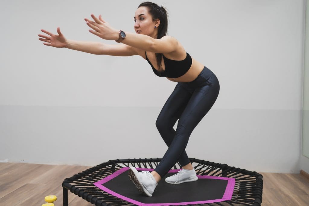 a woman on a mini trampoline doing rebounder therapy for osteoporosis