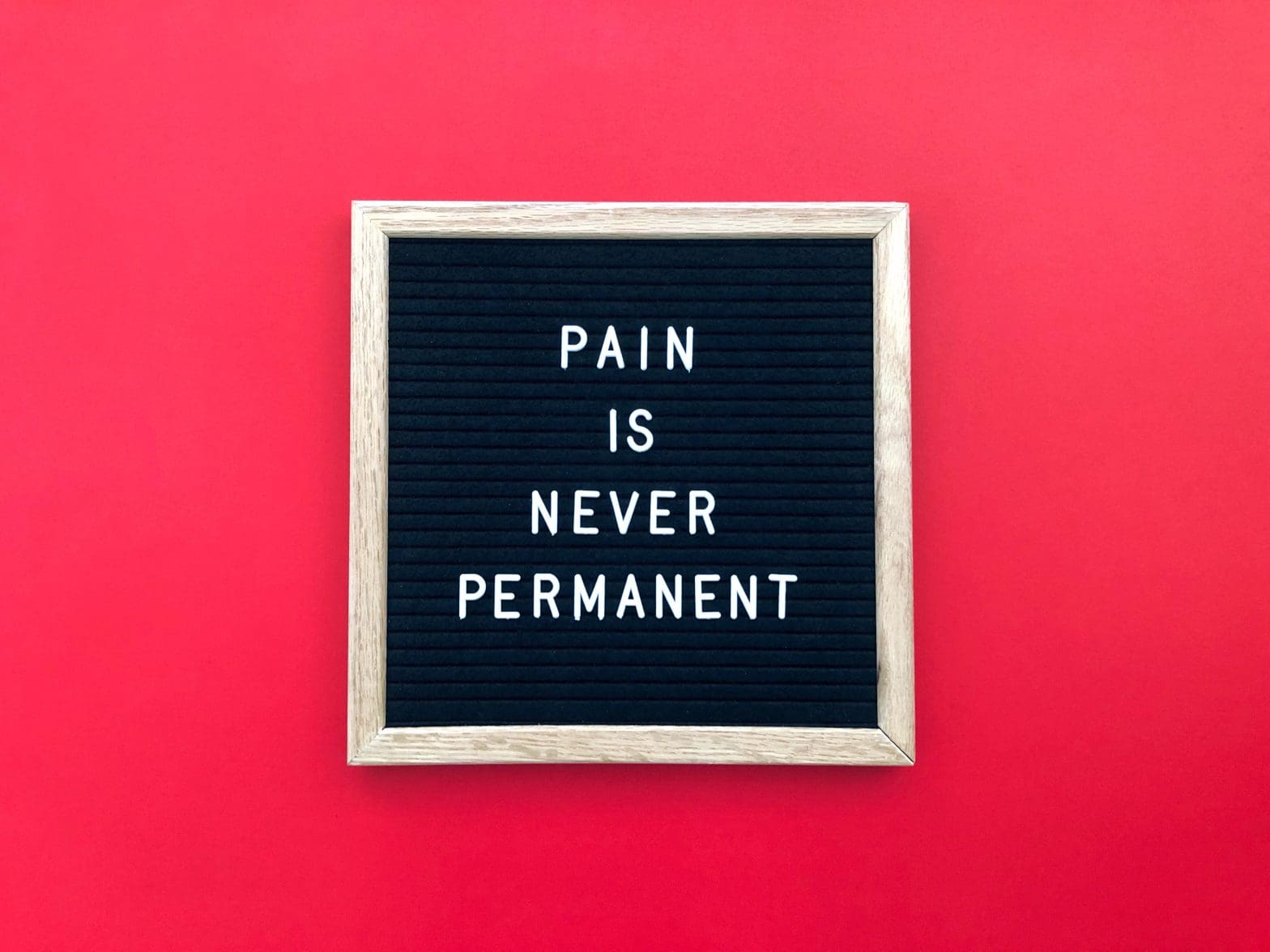 a sign that says "pain is never permanent" highlighting red light therapy for pain and inflammation