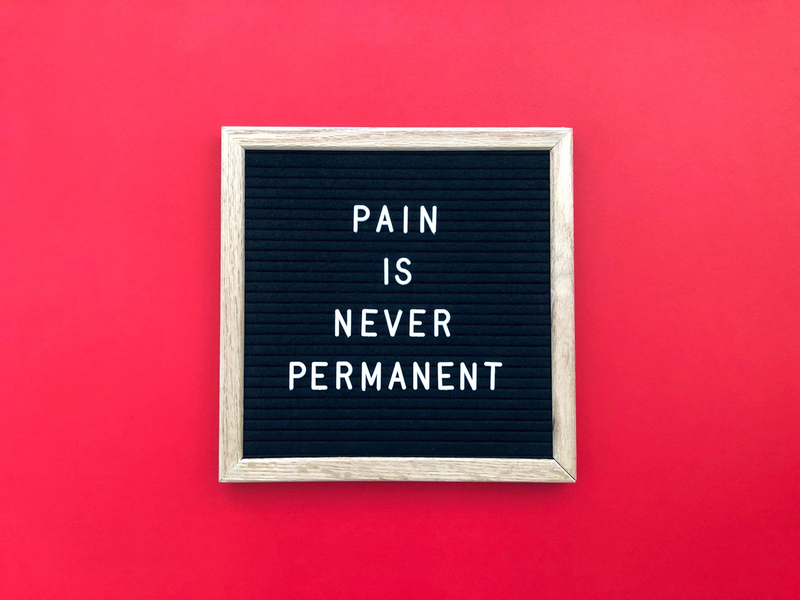 a sign that says "pain is never permanent" highlighting red light therapy for pain and inflammation
