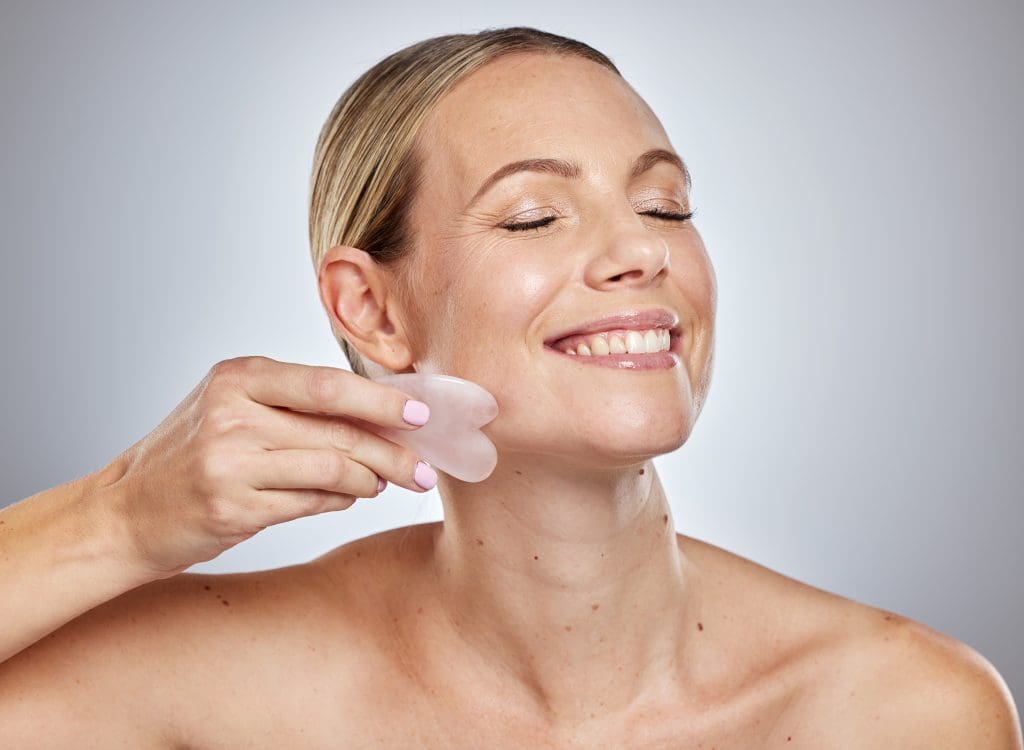 a woman using gua sha facial lift and sculpt skin