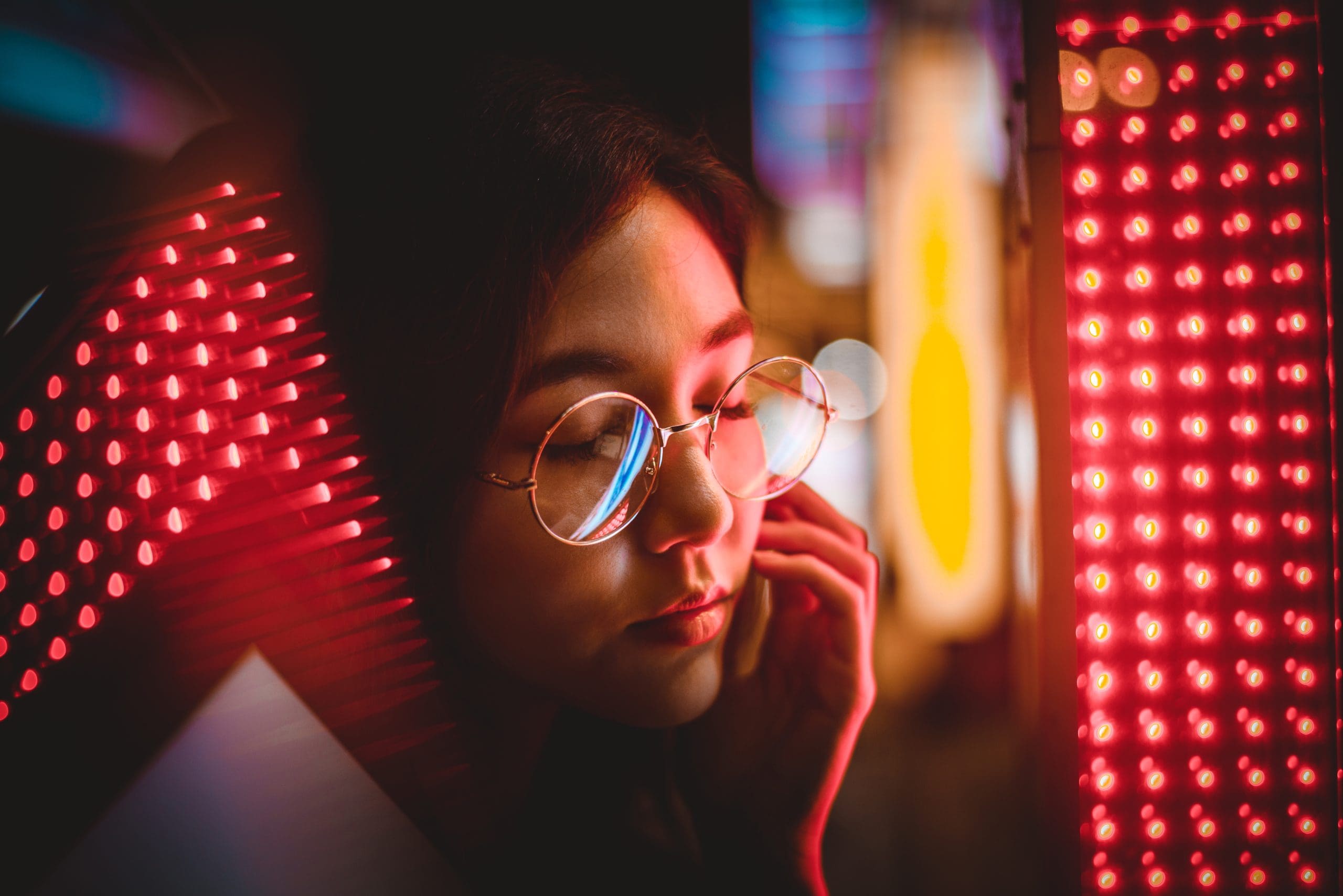 a woman using red light therapy to help her sleep