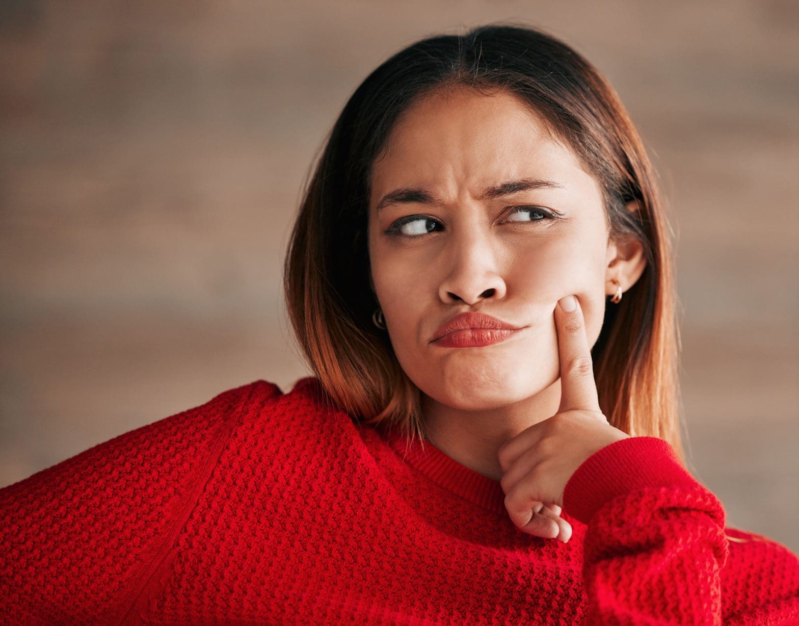 a woman with her finger to her cheek, wondering what the difference is between traditional sauna vs. ozone sauna