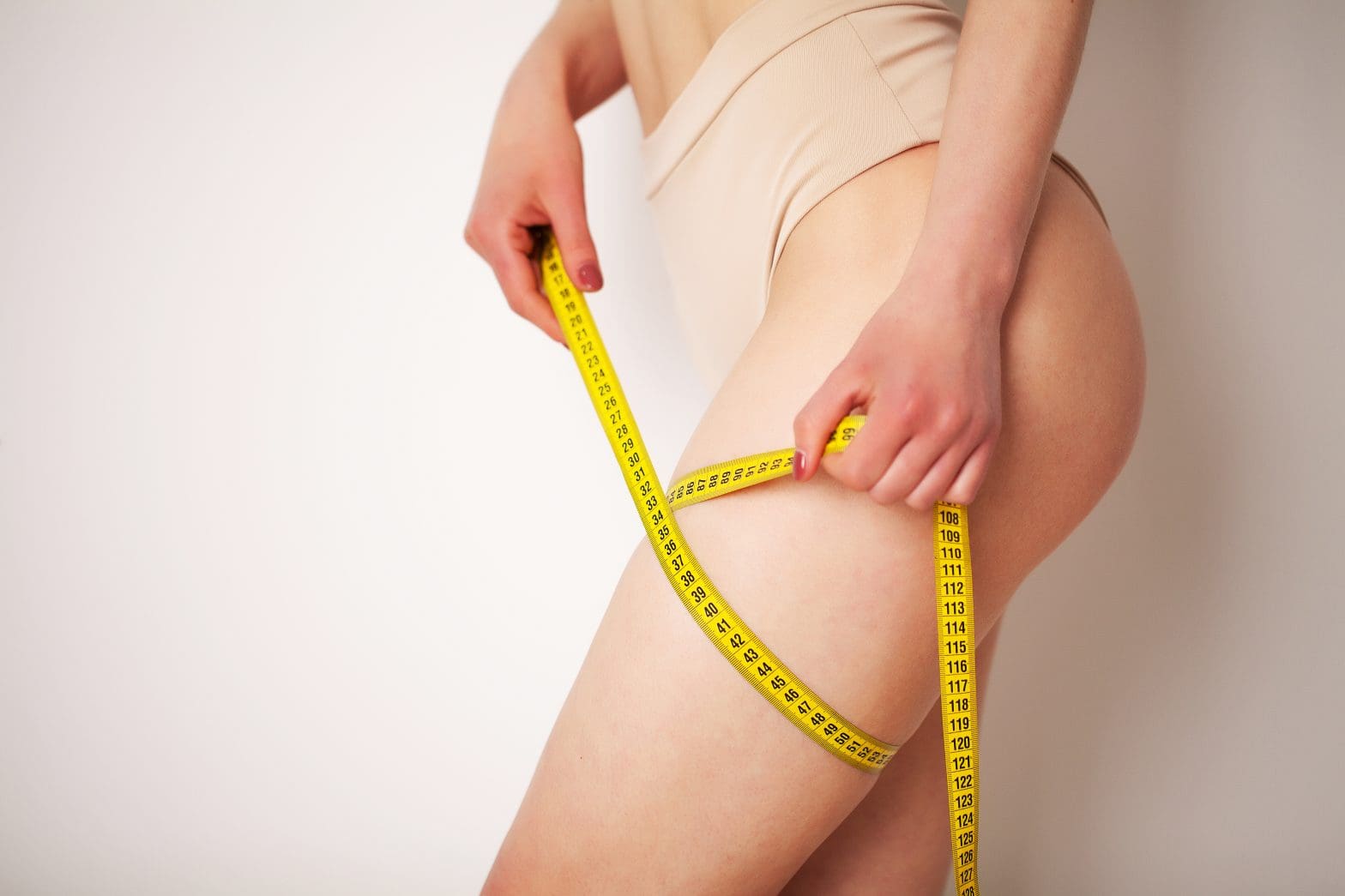 a woman measuring the size of her leg after endospheres therapy for lipedema
