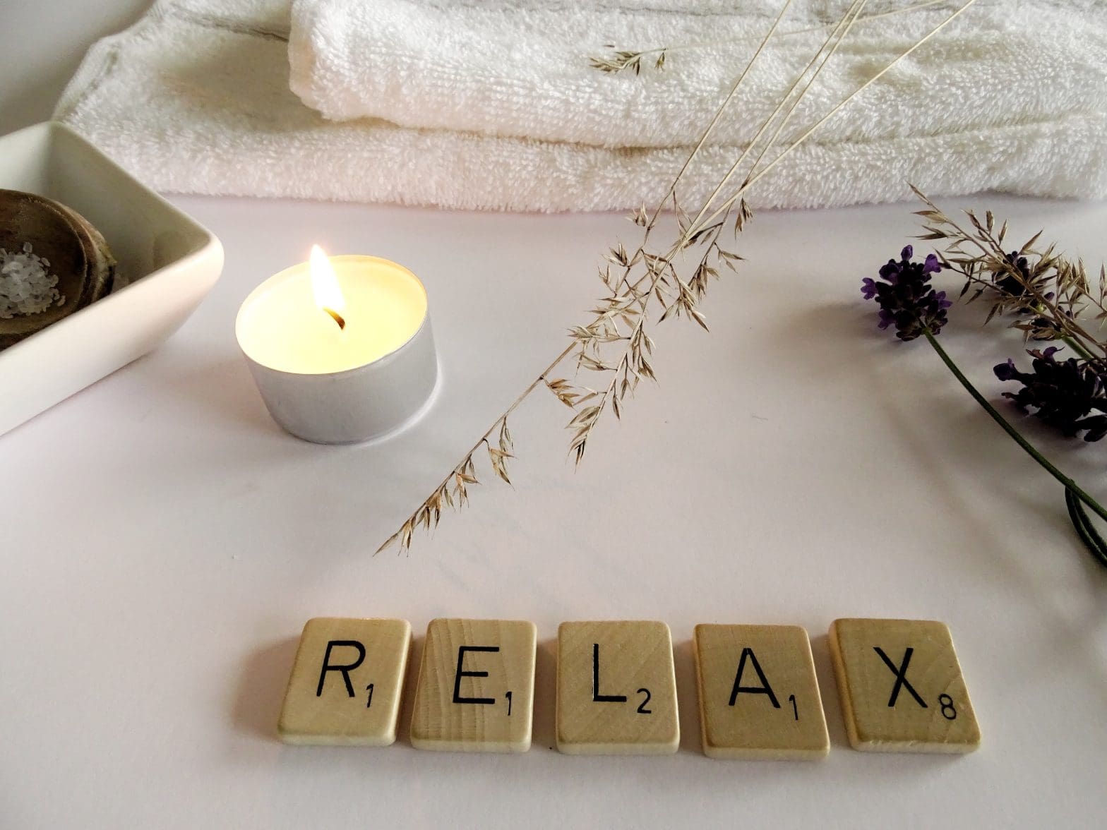 wooden letters that spell "relax" among many relaxing items to emphasize the importance of World Mental Health Day