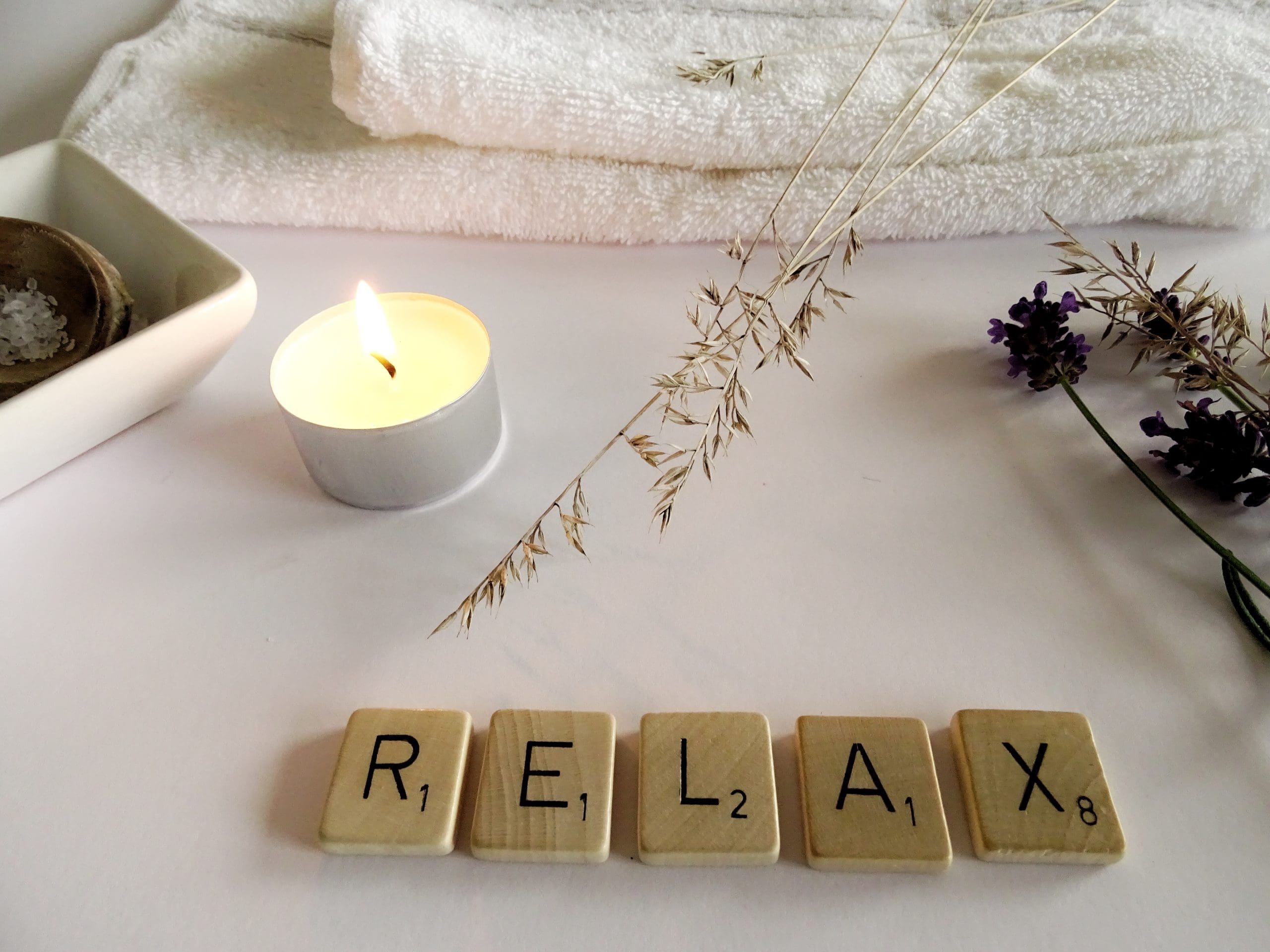 wooden letters that spell "relax" among many relaxing items to emphasize the importance of World Mental Health Day