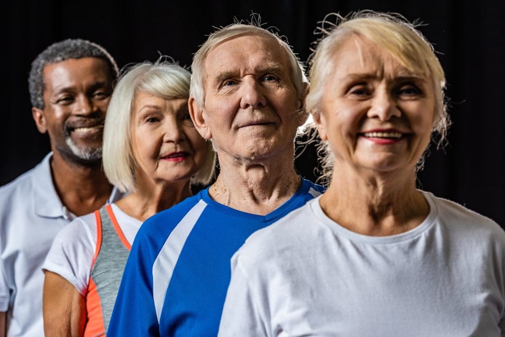 4 older people in a line against a black background to show how effective holistic spa treatments for seniors are