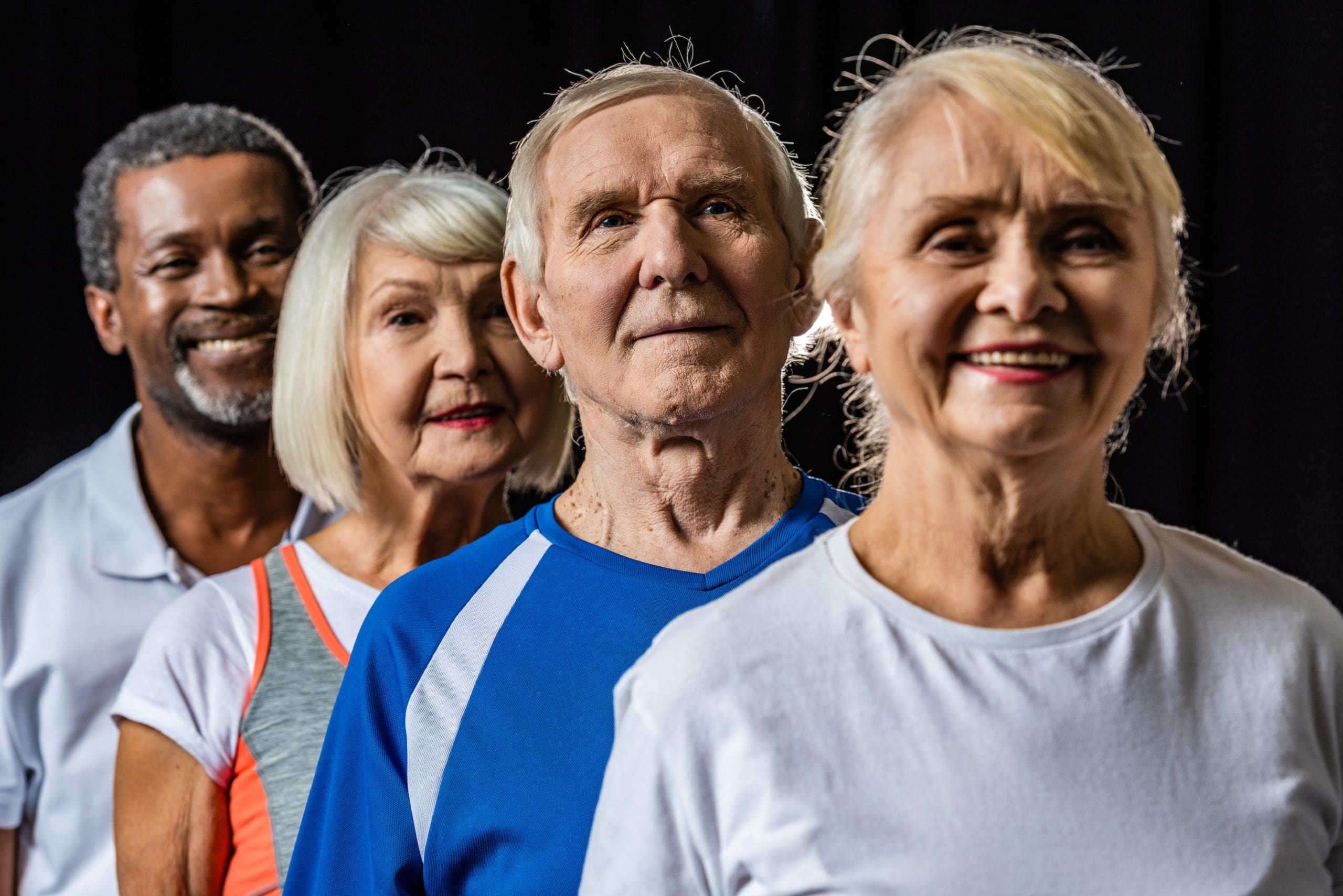 4 older people in a line against a black background to show how effective holistic spa treatments for seniors are