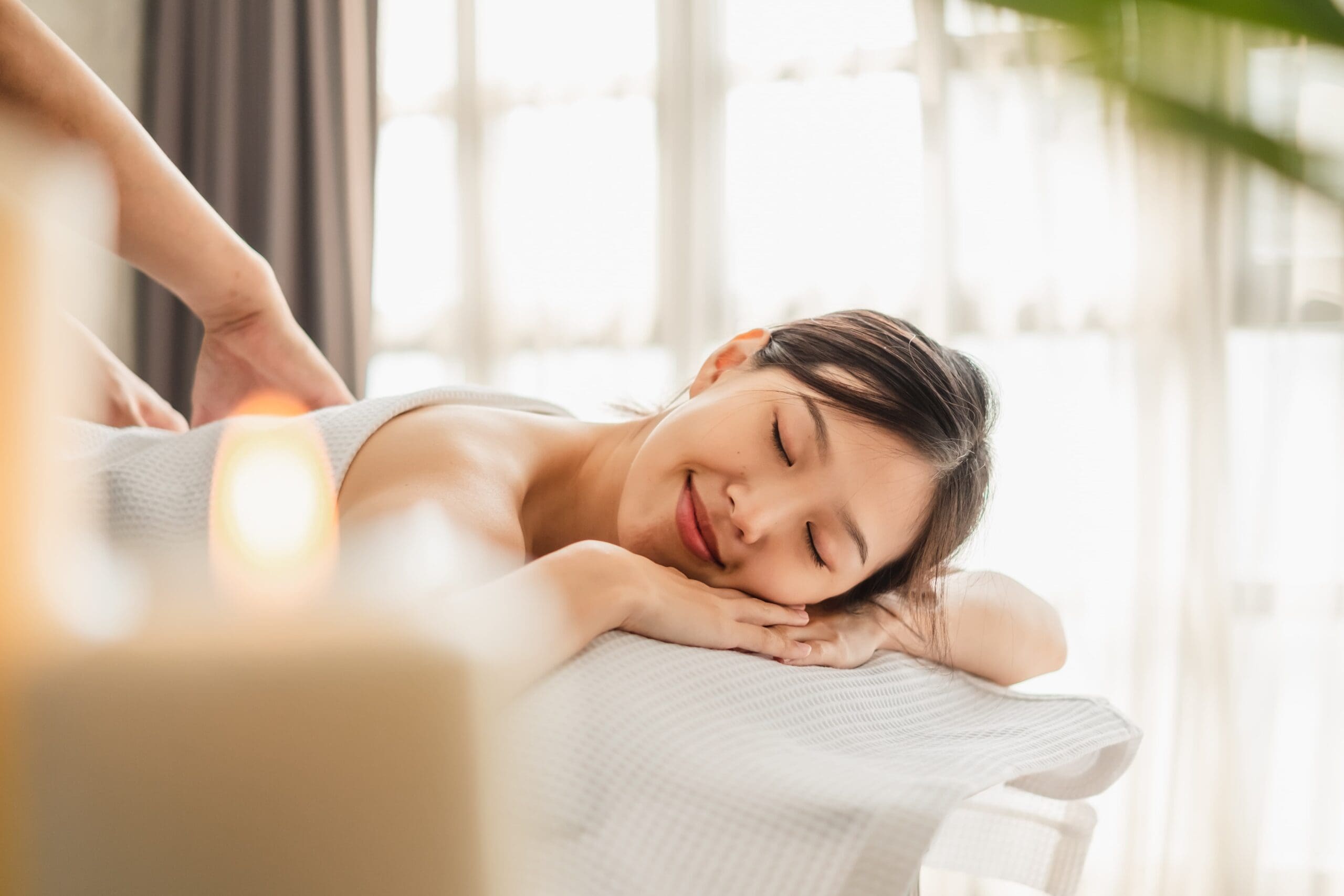 woman enjoying a peaceful spa treatment in a serene, candlelit setting promoting mindfulness and relaxation